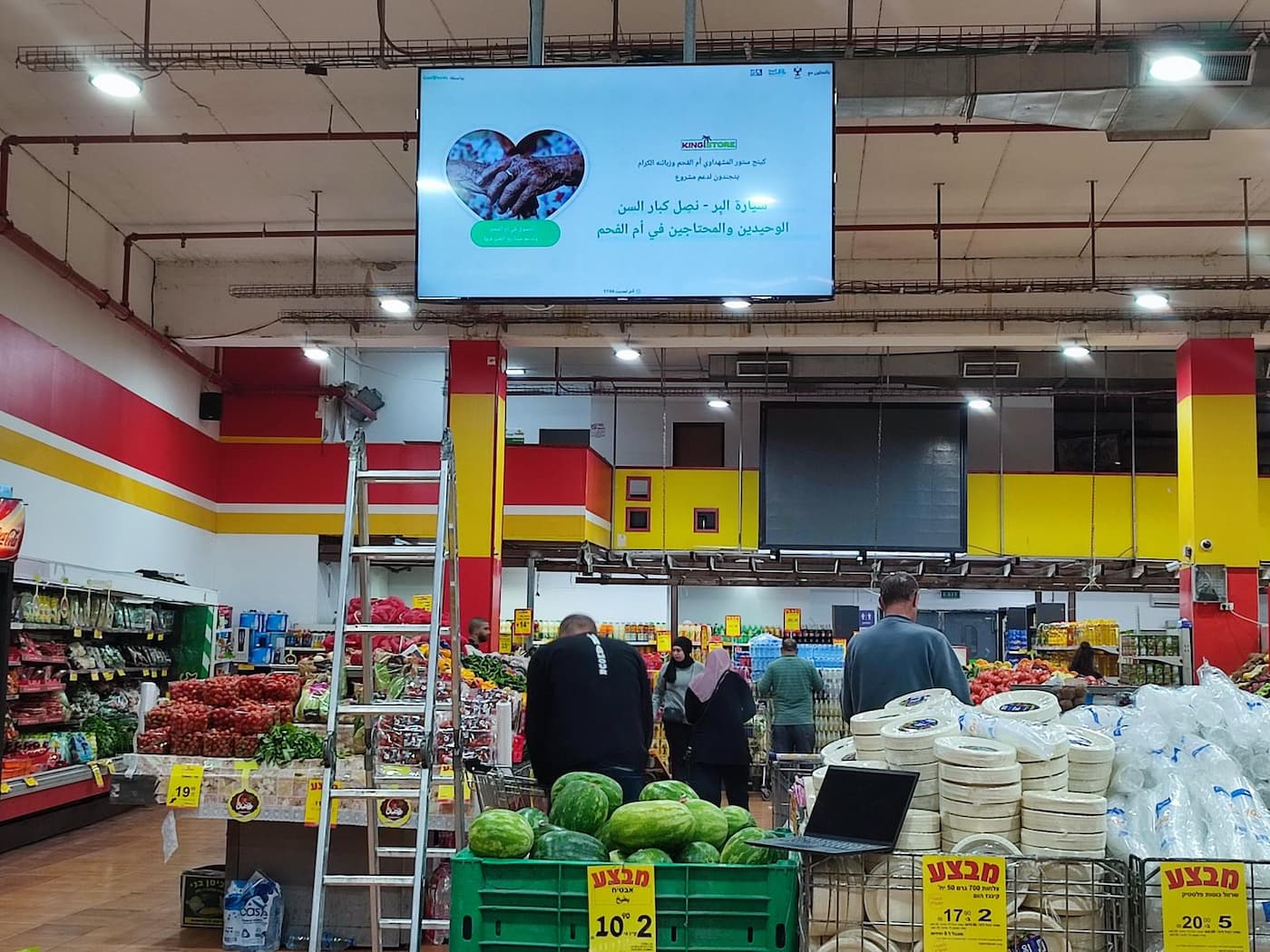 A photo taken at the local supermarket that shows a big screen with the live total number of donations.